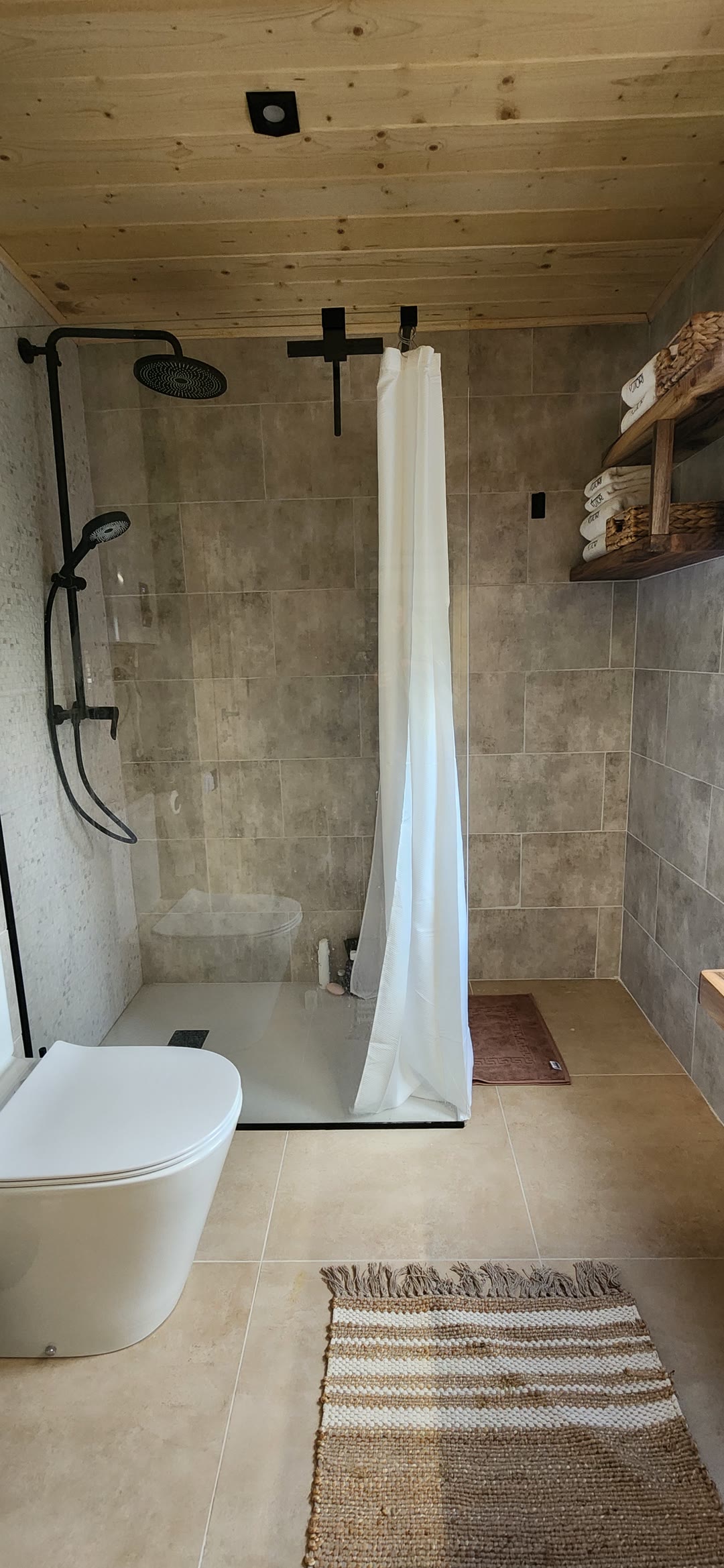 The shower behind glass and a woven mat