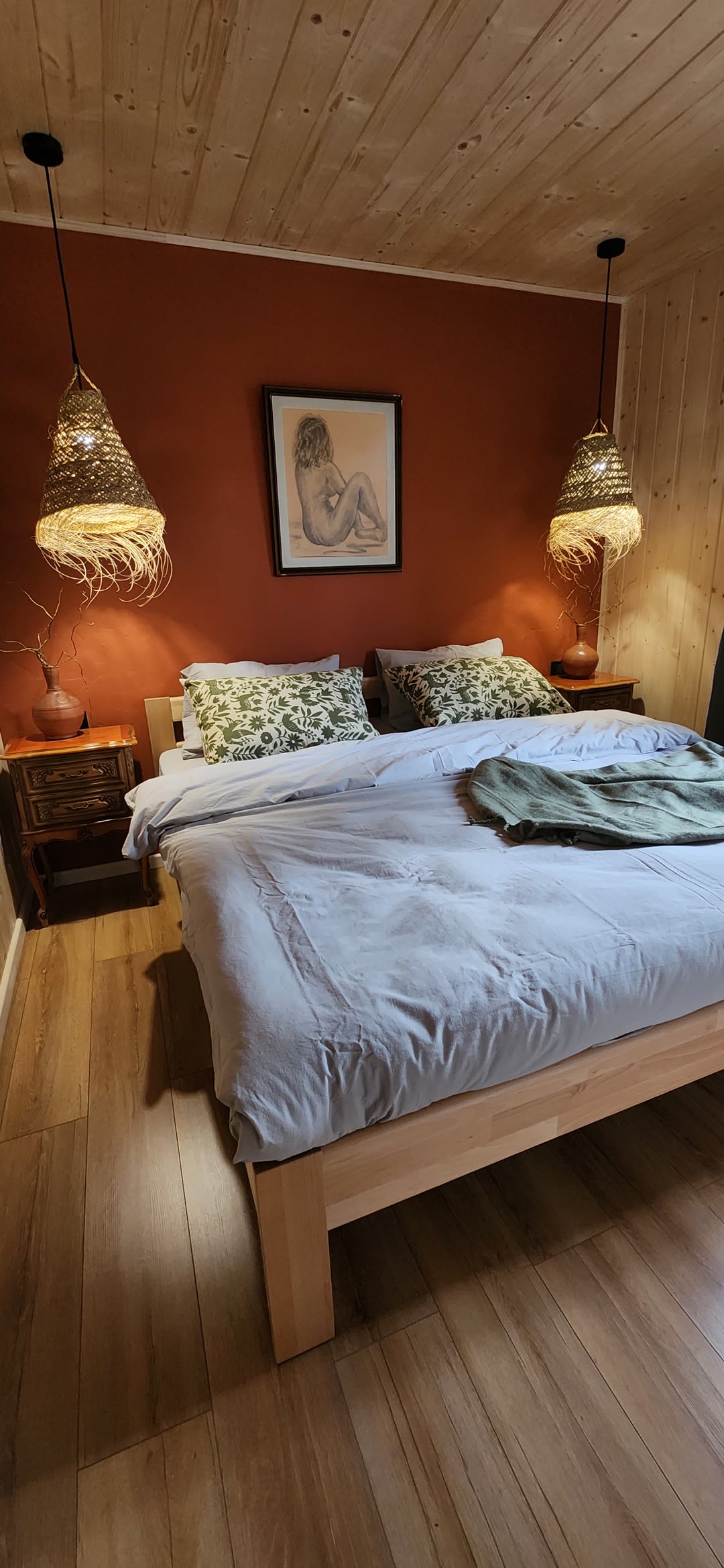 The bedroom from the door: bed, bedside table and lamp