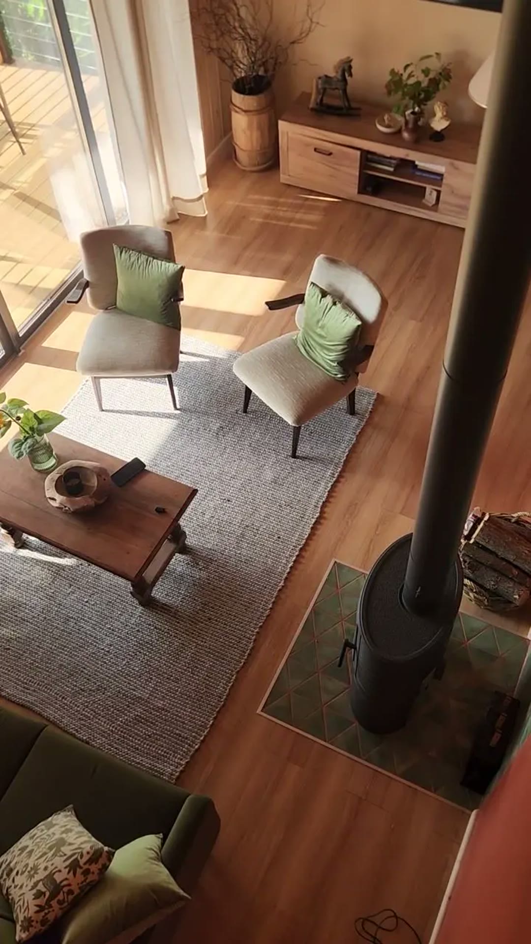 The living room from above: two chairs with green cushions, a rug and the fireplace