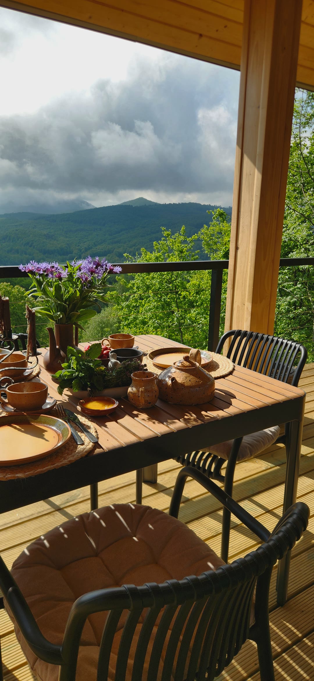 A breakfast table on the terrace, mountains in cloud