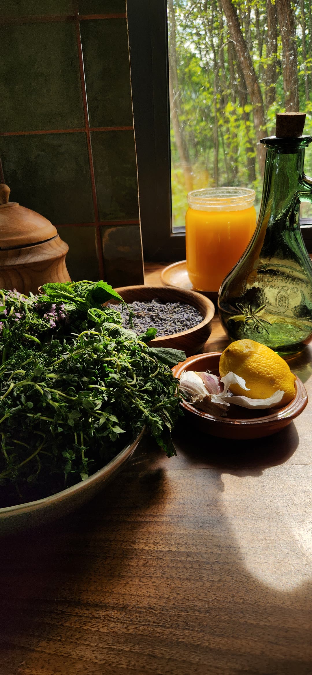 Fresh herbs, honey, oil, lemon and garlic by the window