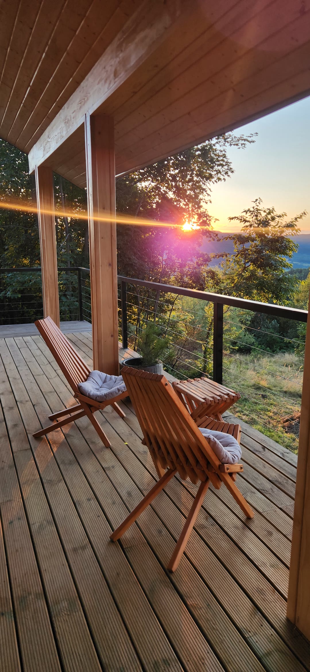 Two wooden chairs on the terrace at sunrise over the valley